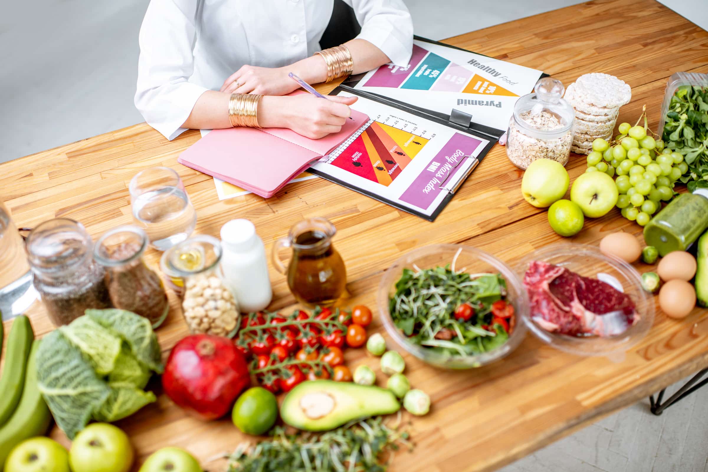 Writing a diet plan on the table full of healthy food